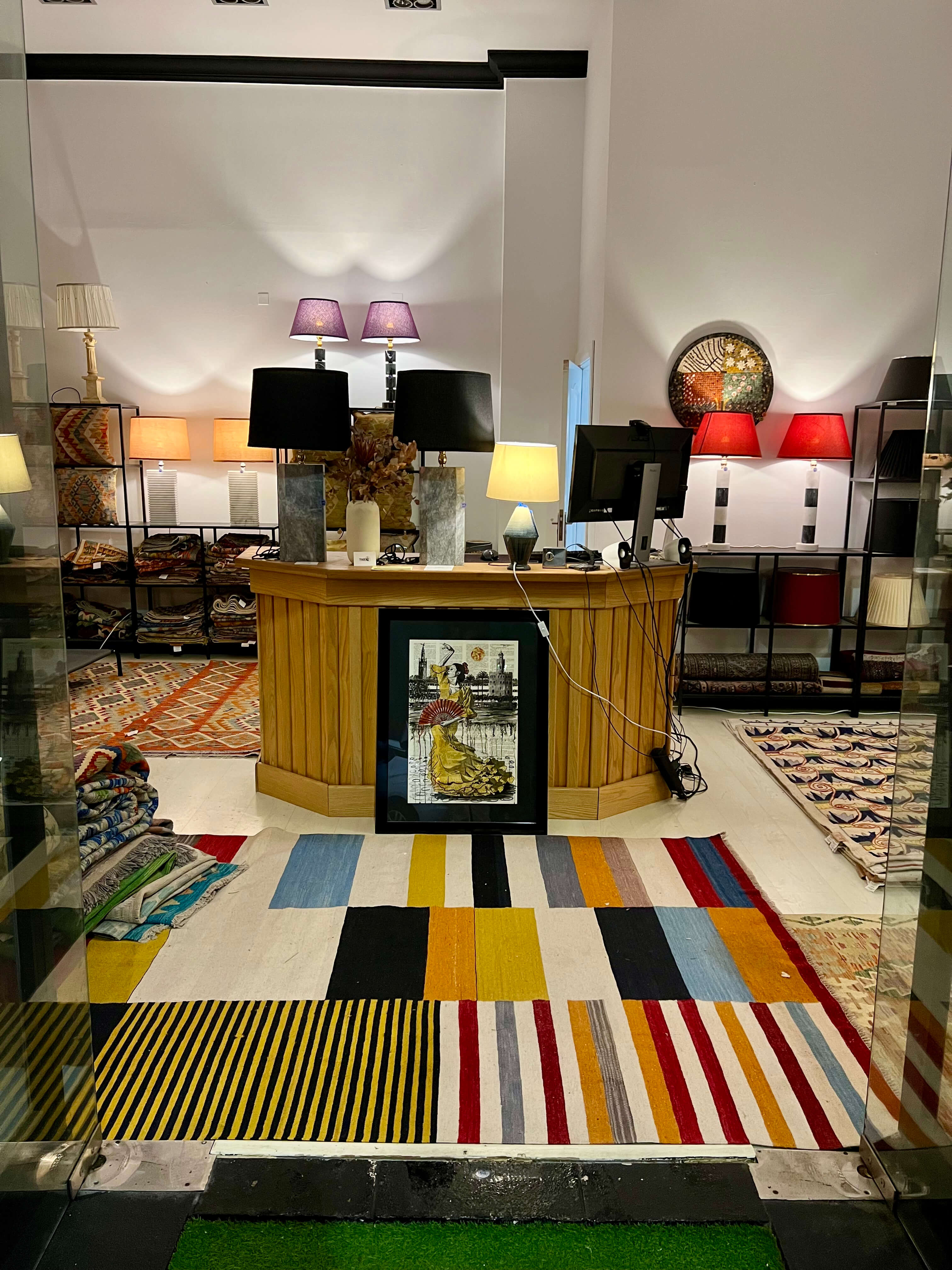 Tradexx showroom at estepona showing a modern interior design with a colorful geometric kilim rug, wooden desk, and other decorative items.